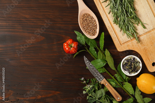 Assorted spices with fresh herbs on a wooden background. Natural food additives. Aromatic herbs and spices from garden, healthy cooking concept. Flat lay, top view