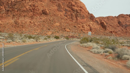 Road trip, driving auto in Valley of Fire, Las Vegas, Nevada, USA. Hitchhiking traveling in America, highway journey. Red alien rock formation, Mojave desert wilderness looks like Mars. View from car.