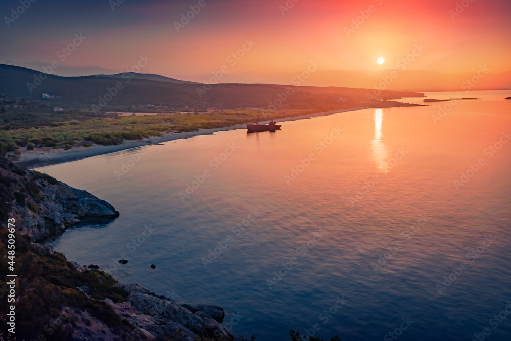 Dramatic sunrise on Valtaki beach with Dimitrios Shipwreck. Breathtaking morning scene of Peloponnese peninsula, Greece, Europe. Spectacular summer seascape of Mediterranean sea.