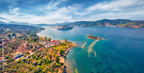 Fototapeta Naklejka Na Ścianę i Meble -  Fantastic summer view of Plaka beach and Poros town on background. Amazing morning seascape of Mediterranean sea with a lots of yachts. Colorful outdoor scene of Peloponnese peninsula, Greece.