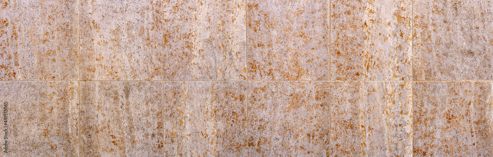 Zwei Reihen große Steinfliesen mit abstraktem Muster in grau orange braun an einer Fassade in Panorama Nahaufnahme Zwei Reihen große Steinfliesen mit abstraktem Muster in grau orange braun an einer Fassade in Panorama Nahaufnahme