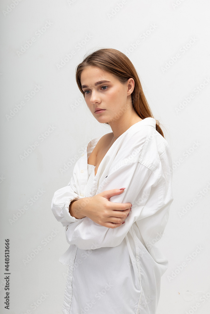 young attractive caucasian woman with long brown hair in shirt, blue jeans on white studio background. skinny pretty lady posing at bright room. portrait of beautiful female young attractive caucasian woman with long brown hair in shirt, blue jeans on white studio background. skinny pretty lady posing at bright room. portrait of beautiful female