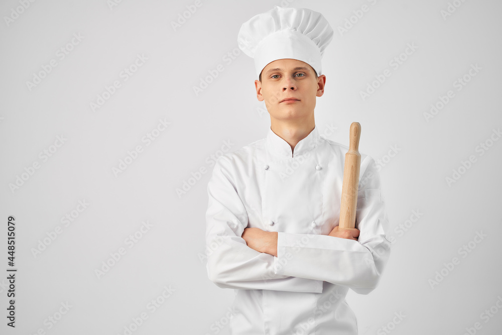 a man in a chef's uniform holding a rolling pin cooking food restaurant kitchen a man in a chef's uniform holding a rolling pin cooking food restaurant kitchen