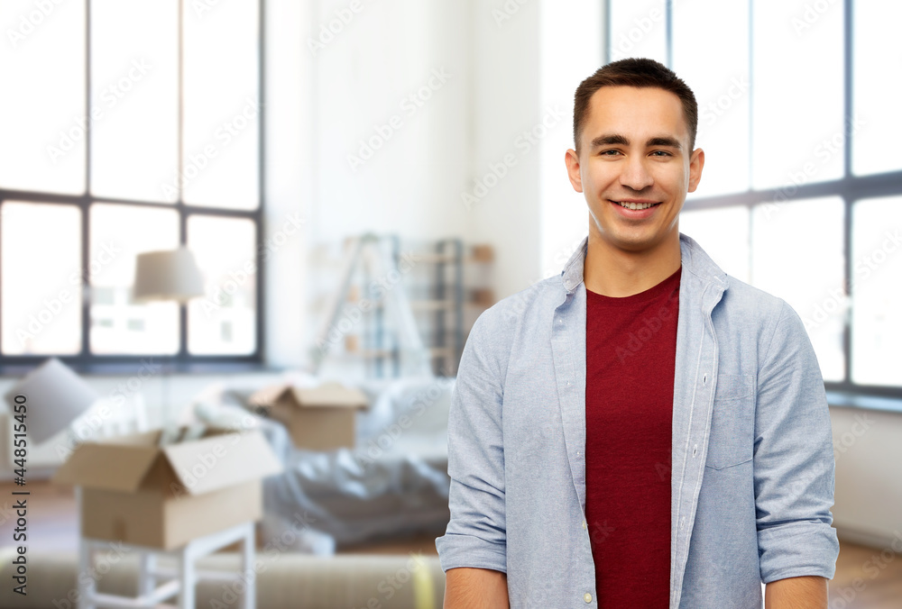 moving, real estate and people concept - smiling young man over new home background moving, real estate and people concept - smiling young man over new home background
