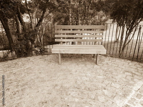A rustic square bench in a park in southern Brazil, in vintage style photography 