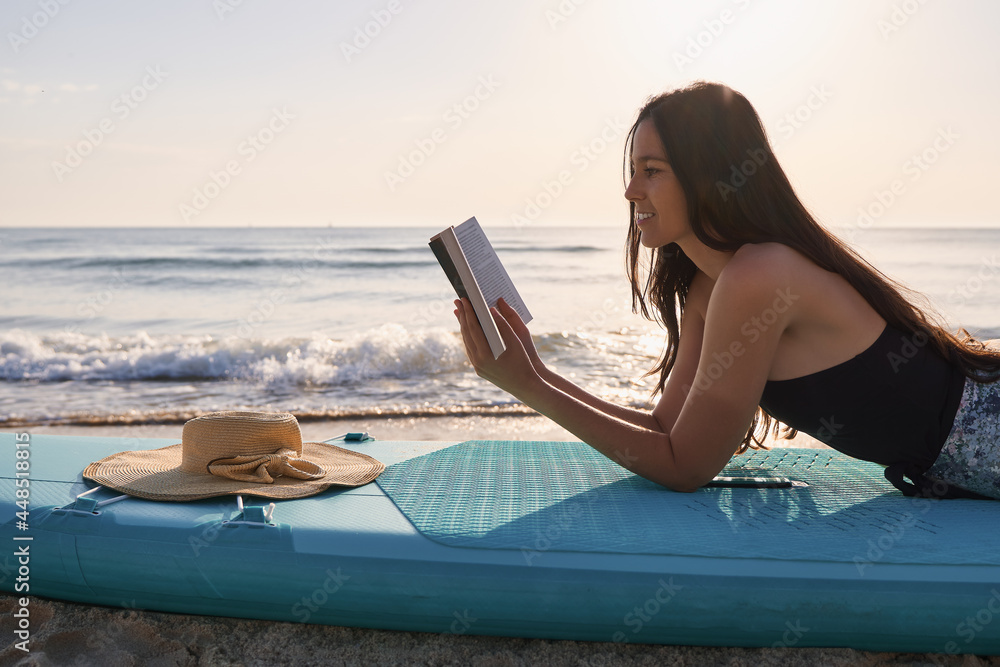 Young woman reading a book on the beach