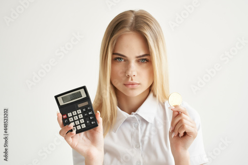 woman in white shirt calculator gold coin cryptocurrency