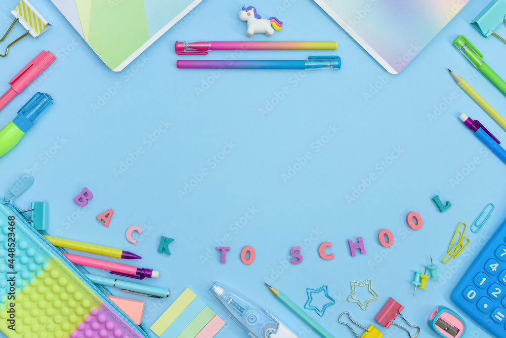 Frame made of colorful school and office stationery on blue background with copy space. Pencil case, calculator, unicorn, pens and pencils, stitches and curly paper clips. Preschool Education concept. Frame made of colorful school and office stationery on blue background with copy space. Pencil case, calculator, unicorn, pens and pencils, stitches and curly paper clips. Preschool Education concept.