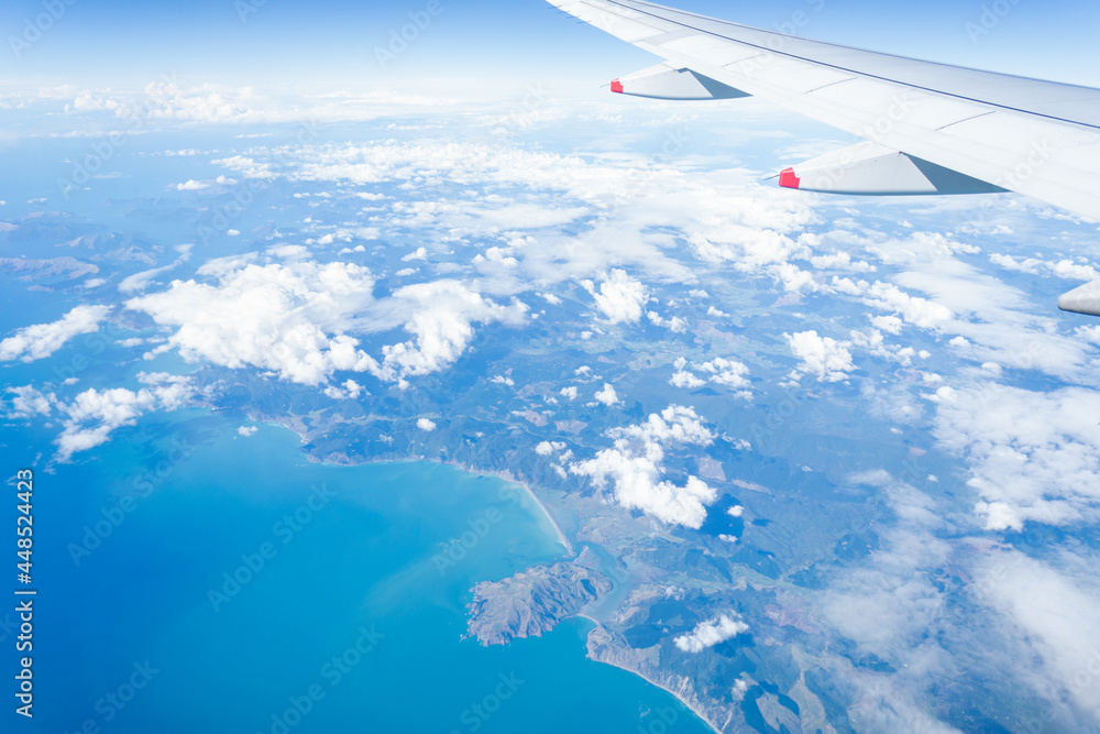 Aerial view of mountains and sea from an airplane flying above South Island of New Zealand