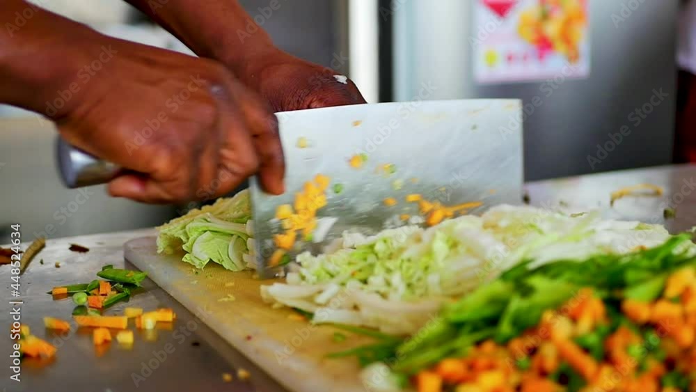 a chef chopping vegetable with a cleaver knife on a white cutting board slow motion, static shot a chef chopping vegetable with a cleaver knife on a white cutting board slow motion, static shot
