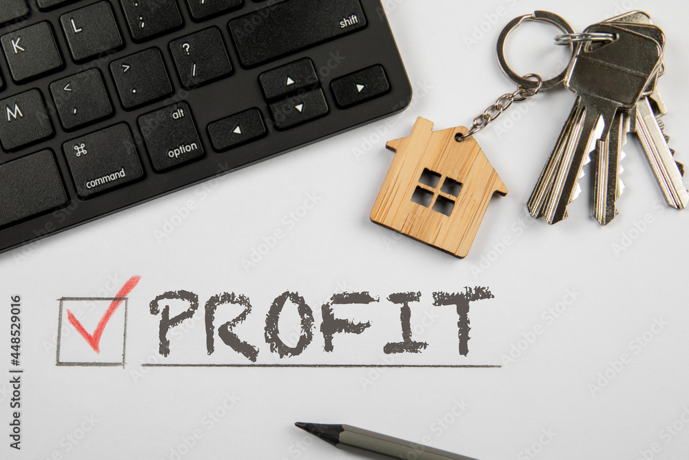 Pprofit. Sale or lease of property concept. Home keys and computer keyboard on desk Pprofit. Sale or lease of property concept. Home keys and computer keyboard on desk