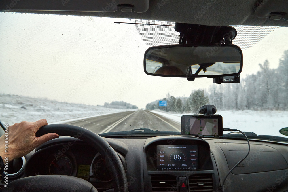 Siberia, Russia - November 28, 2020: View from of car interior from side of driver to the road and nature landscape through the windshield Siberia, Russia - November 28, 2020: View from of car interior from side of driver to the road and nature landscape through the windshield
