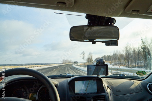 Siberia, Russia - November 28, 2020: View from of car interior from side of driver to the road and nature landscape through the windshield