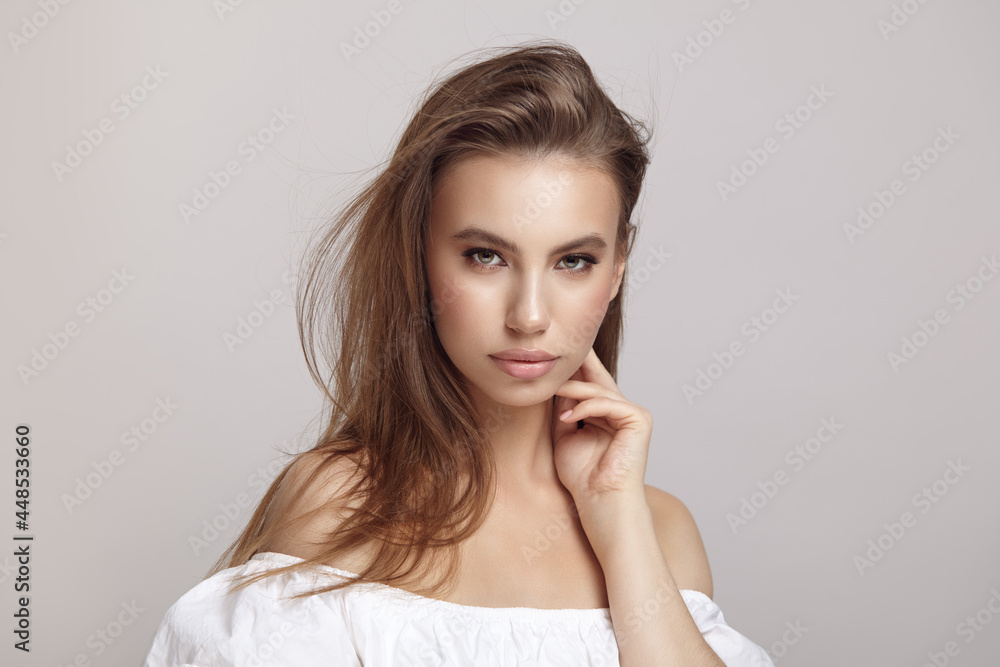 Seductive woman touches cheek looking at camera in studio Seductive woman touches cheek looking at camera in studio