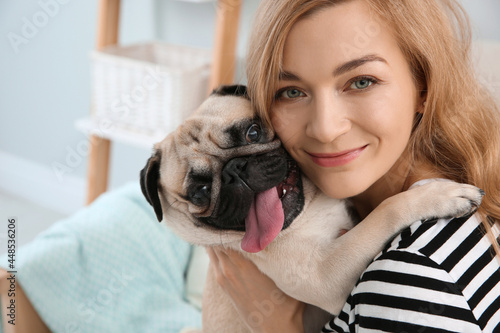 Woman with cute pug dog at home. Animal adoption © New Africa