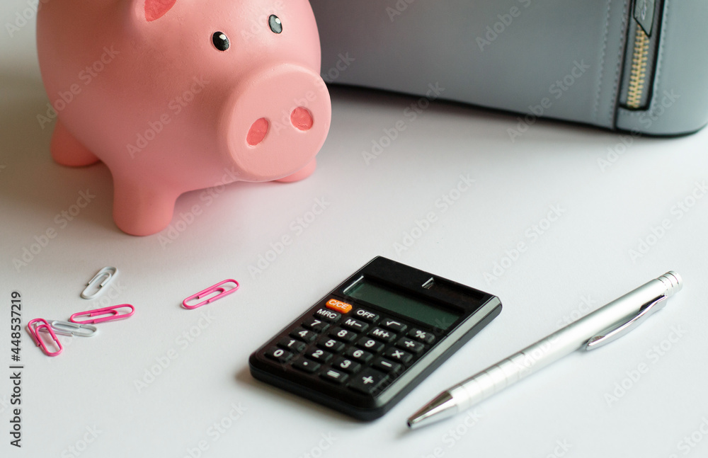 Piggy bank and calculator for saving money with business stuff, Business and finance concept Piggy bank and calculator for saving money with business stuff, Business and finance concept