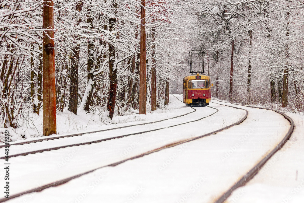 An old tram moving through a winter forest An old tram moving through a winter forest