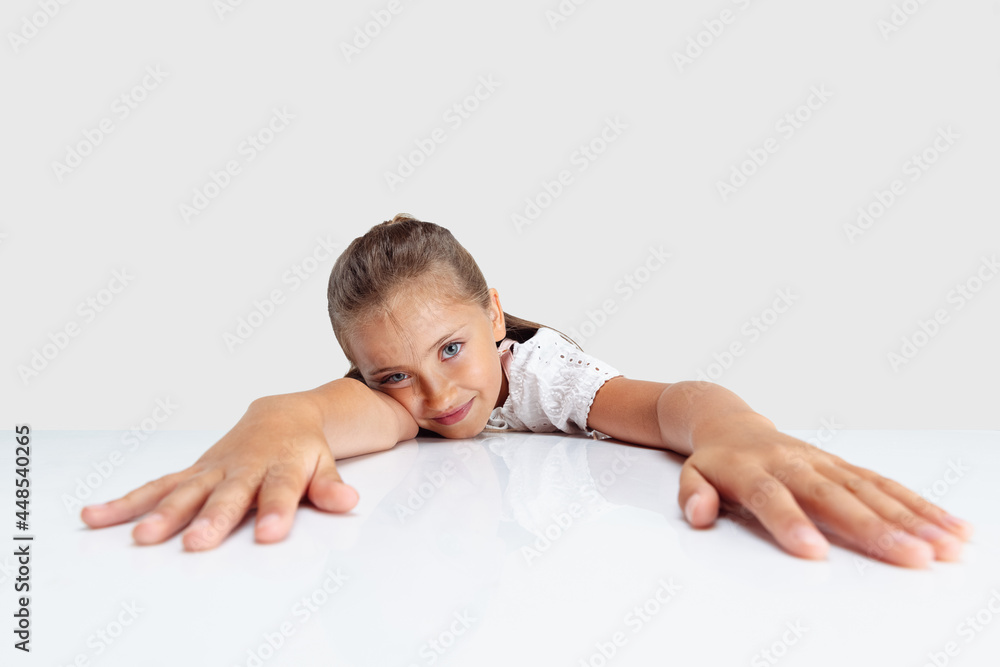 One Caucasian school girl, pupil isolated over white studio background. Copyspace. Childhood, education, emotions concept. Looks tired One Caucasian school girl, pupil isolated over white studio background. Copyspace. Childhood, education, emotions concept. Looks tired