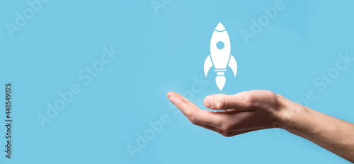 Photos Male hand holding rocket icon that takes off, launch on blue background