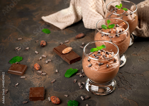 Vegan chocolate mousse with mint, bar of chocolate and cocoa beans on a dark background. photo