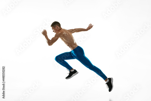 One Caucasian professional male athlete, runner training isolated on white studio background. Muscular, sportive man. Concept of sport, healthy lifestyle