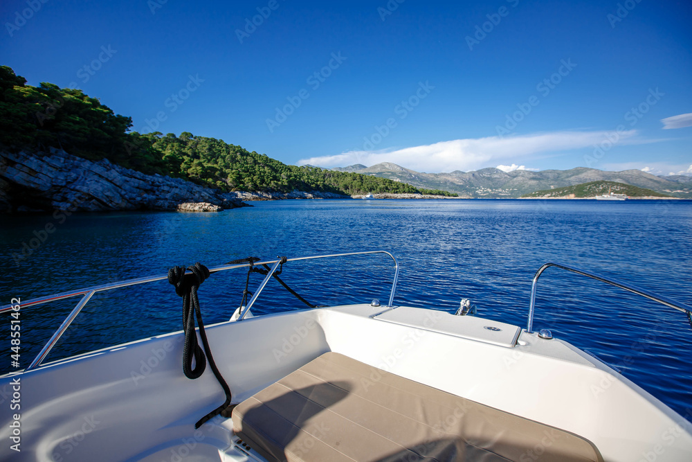 Obraz premium side front of a motor yacht going to the sea towards the mountains. Luxurious travel life. Beautiful view from the boat to the Croatian islands