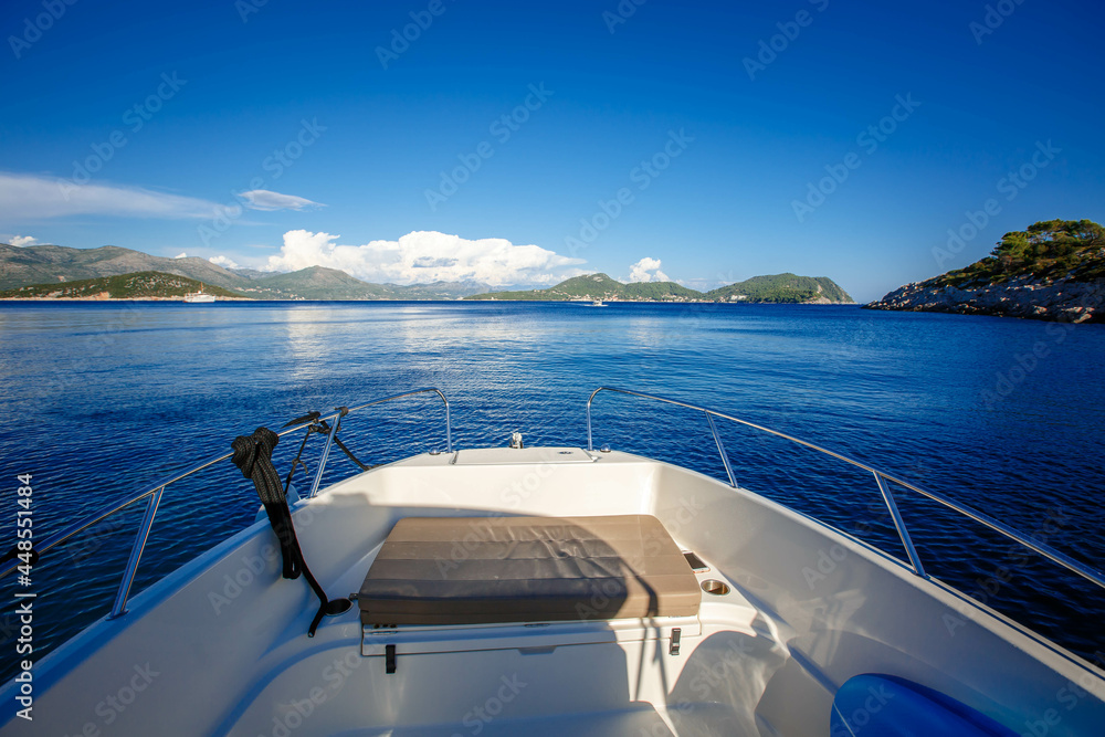 side front of a motor yacht going to the sea towards the mountains. Luxurious travel life. Beautiful view from the boat to the Croatian islands side front of a motor yacht going to the sea towards the mountains. Luxurious travel life. Beautiful view from the boat to the Croatian islands