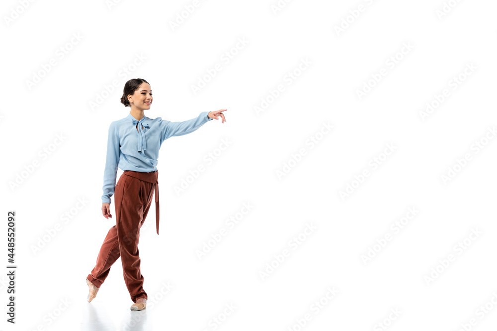 Obraz premium Brunette ballerina pointing with finger on white background