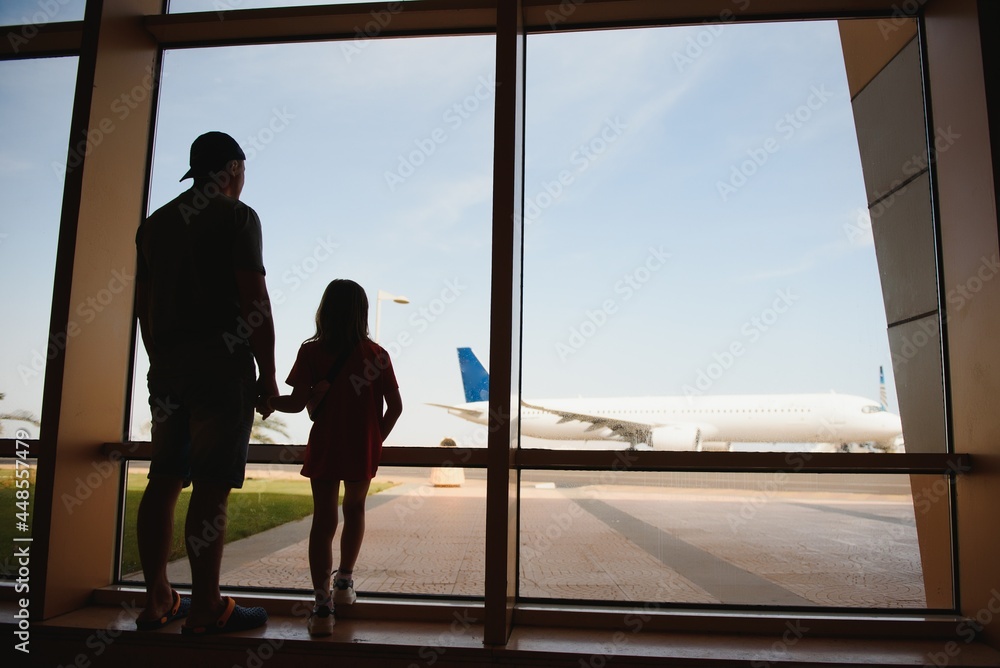 Fototapeta premium Exhausted father and daughter staying at the airport for a long time. Their flight was canceled. Copy space in right side