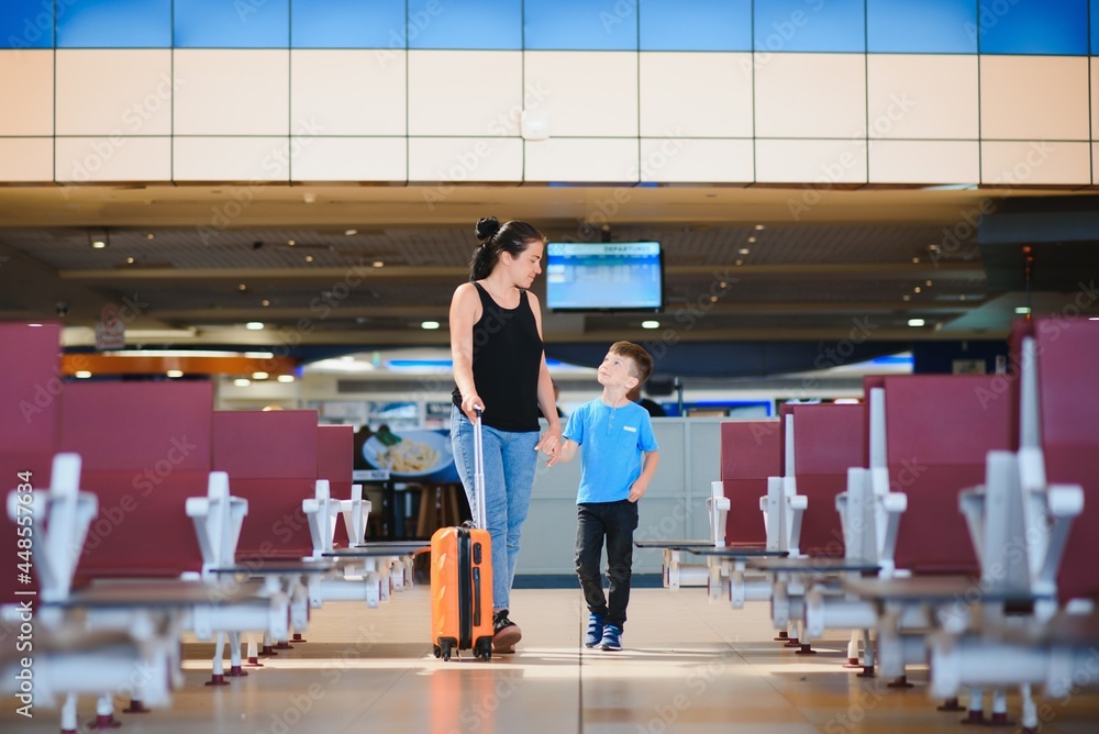 Woman and her child passing through the airport terminal