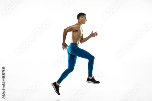 Workout. Young male athlete, runner practicing isolated on white studio background. Muscular, sportive man. Concept of sport, healthy lifestyle