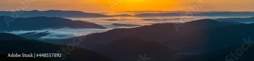 Morning mists illuminated by the rays of the rising sun seen from the summit of Połonina Wetlińska, the Bieszczady Mountains, the Carpathians
