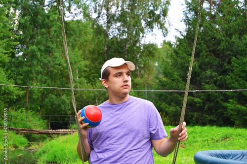 Autistic behavioral traits.A beautiful autistic guy rides with a ball on a swing in the park among the trees photo