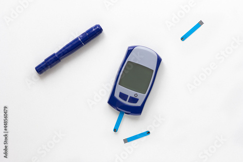 Top view of blood glucose meter, lancet and test strip in it on the white background photo