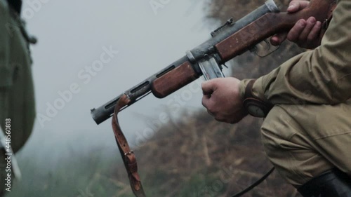 Red Army soldier in soviet uniform with submachine gun PPSh-41 go to battle against German army during reconstruction of invasion to USSR Soviet Union 22 June 1941 at World War 2 on Eastern front photo