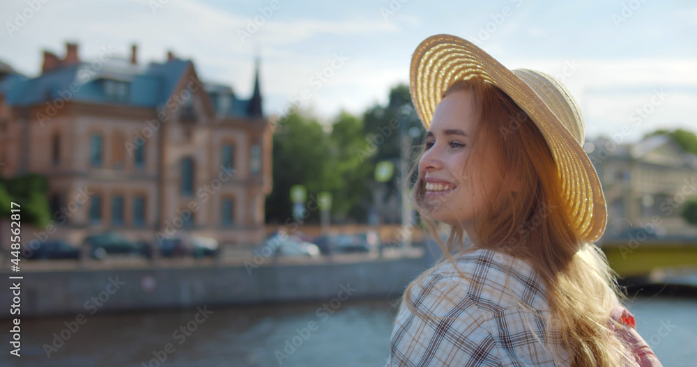 Young blonde woman on vacation smiling happy standing on embankment in city