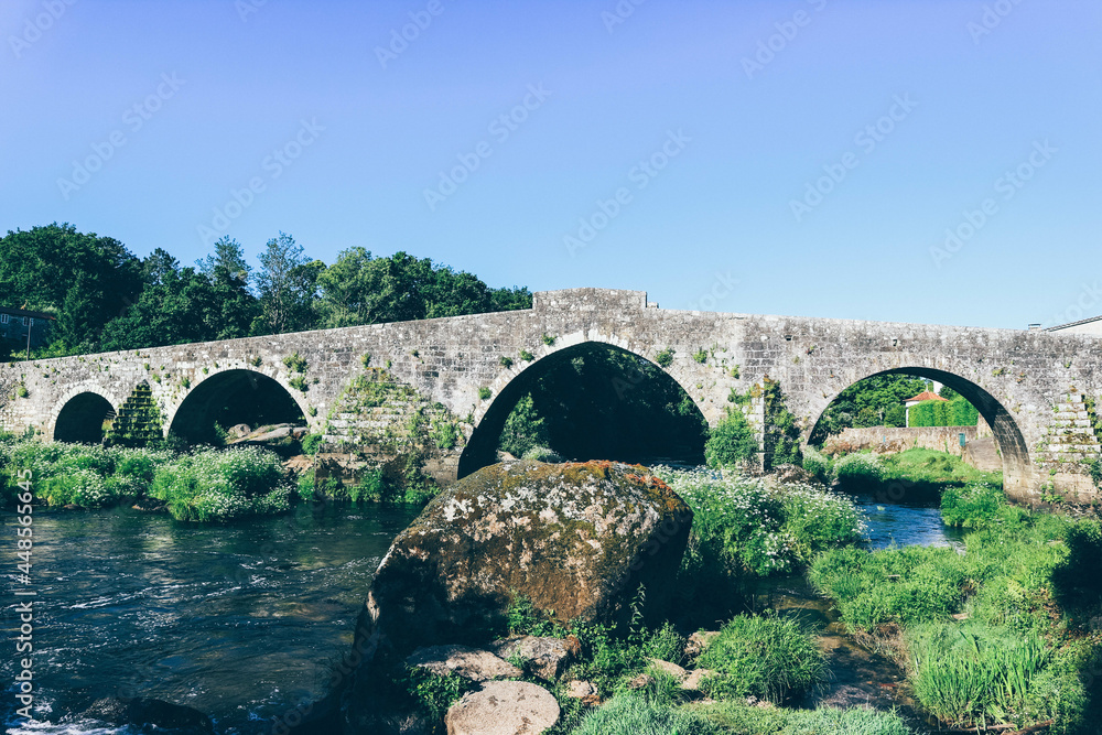 View of the middle age built stone bridge in small Galician village. 