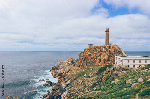 Massive end of road cliff rock with old lighthouse on top in Costa da Morte, Galicia, an historic old very dangerous route for many ships.  © Radu