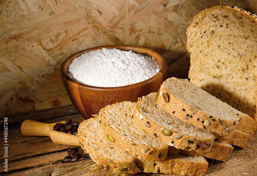 All purpose wheat flour in bowl on wooden background photo