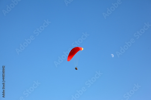 The operated parachute flies in the blue sky