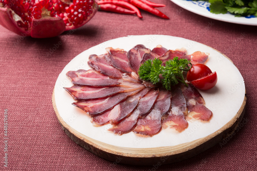 Sliced raw smoked meat served on wooden board Sliced raw smoked meat served on wooden board