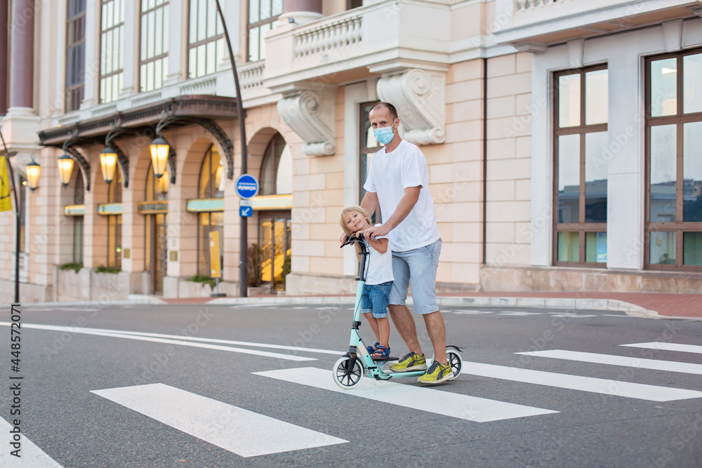 Father and child,  riding scooter in Monaco village on sunset