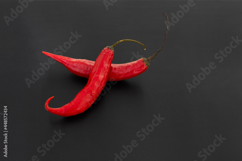 Peppers (red) with black background.