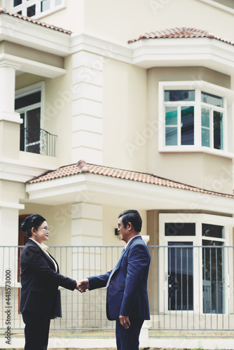 Senior customer shaking hand of real estate broker after buying building © DragonImages