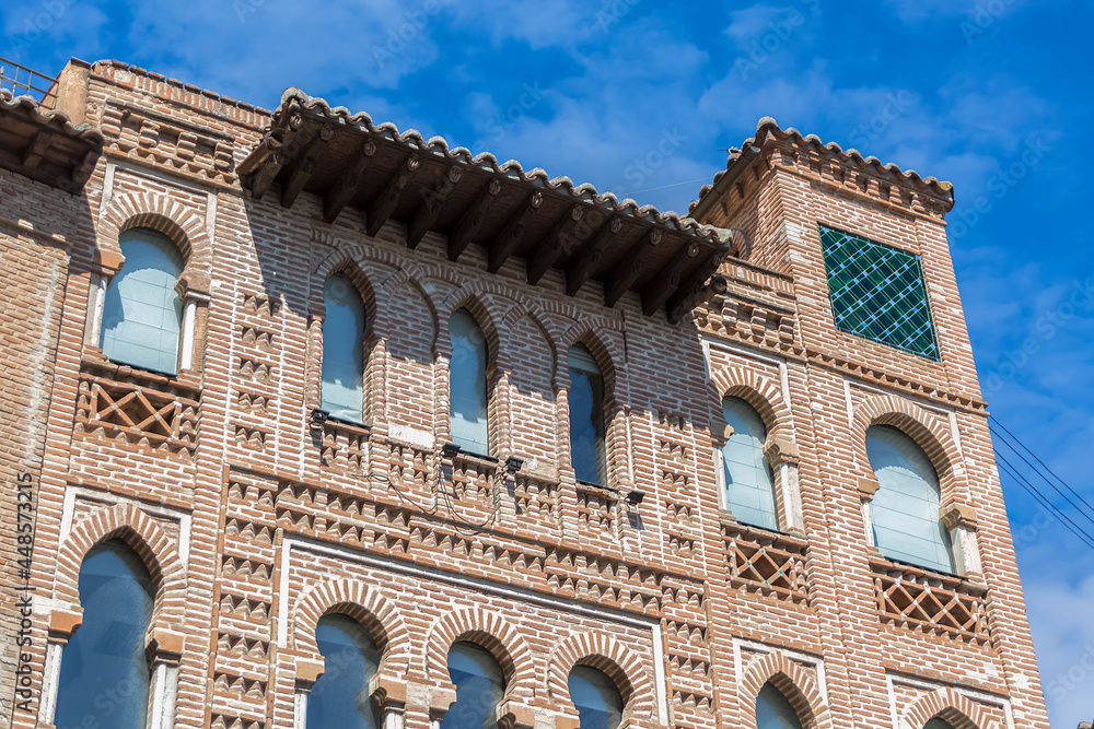 Detailed view of the facade of a Moorish-style building, Arabic architecture with decorative elements, exposed clay brick arches and decorative tiles, in Toledo city