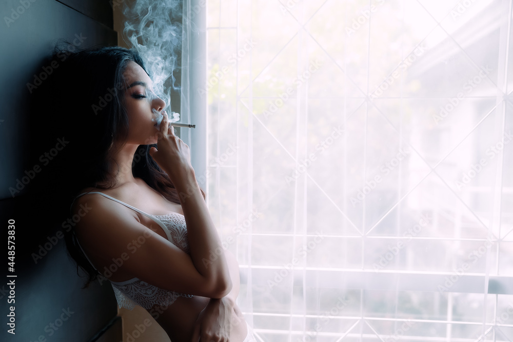 Fototapeta premium young female wearing underwear smoking cigarette indoors