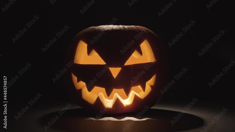 Pumpkin glows on Halloween night. Traditional Halloween symbol. Halloween pumpkin smile and scary eyes for party night. Horror Halloween concept. Pumpkin glows on Halloween night. Traditional Halloween symbol. Halloween pumpkin smile and scary eyes for party night. Horror Halloween concept.
