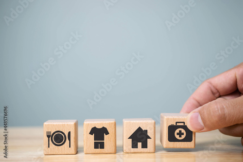 human hand placing cube with food Clothing, housing, medicine, four basic human needs concept. photo