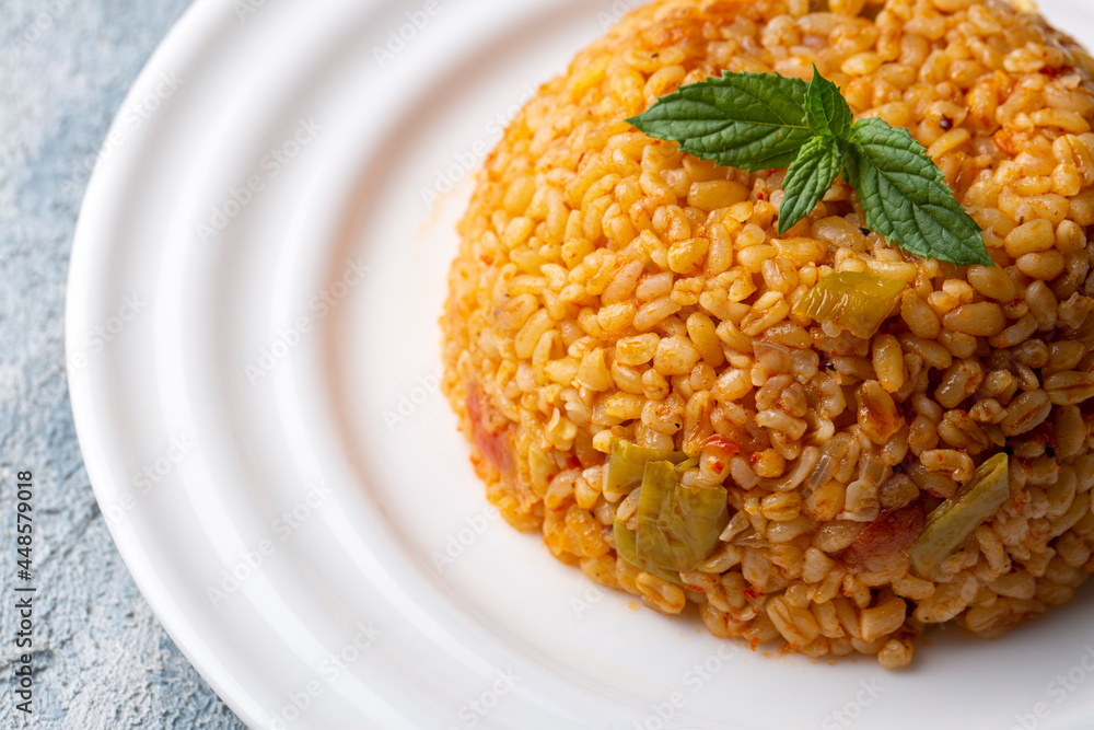 Traditional turkish bulgur pilaf with tomato sause in plate (Turkish name; meyhane pilavi) Traditional turkish bulgur pilaf with tomato sause in plate (Turkish name; meyhane pilavi)