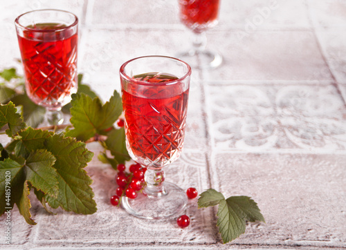 Obraz na plátně glasses of red currant brandy liqueur with ripe berries